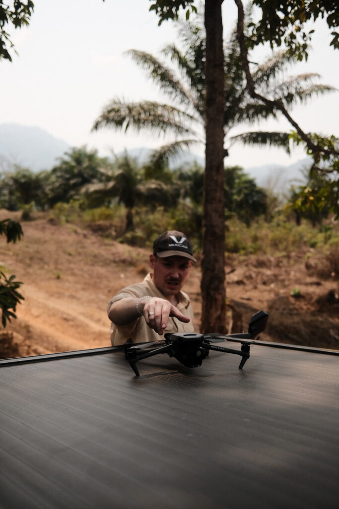 Tom placing a drone on a car bonnet
