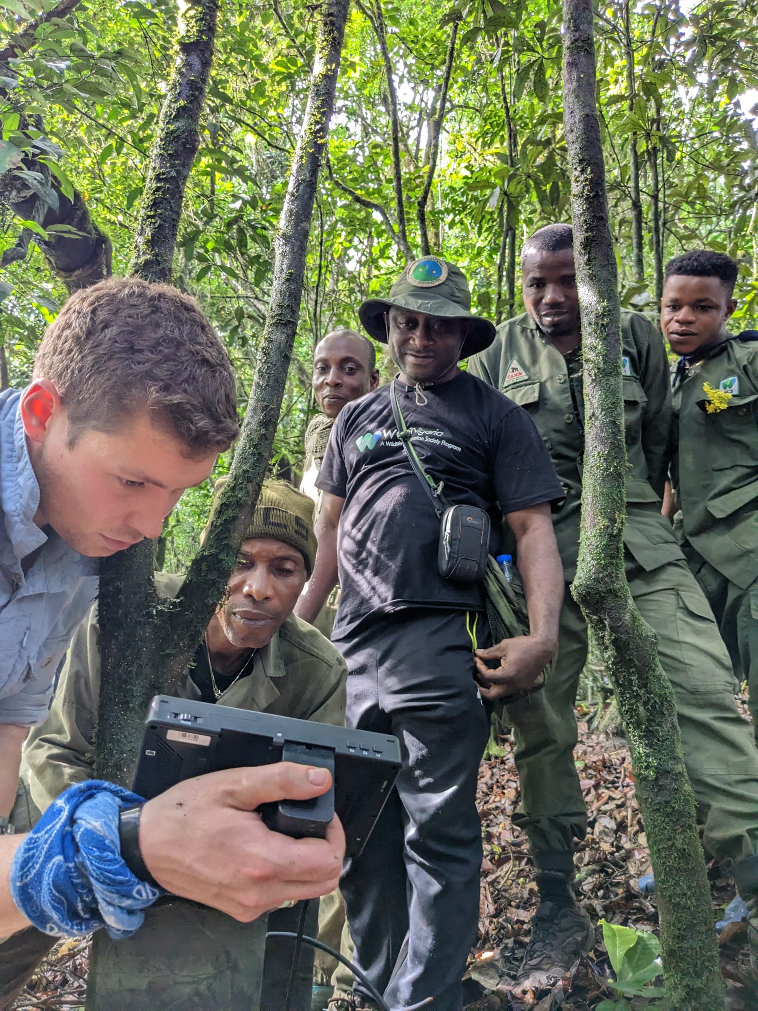 Tom showing rangers the image from a camera trap through a directors monito